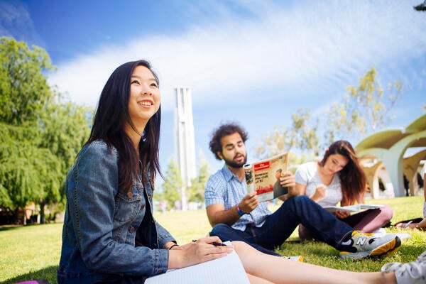 Business Students on University lawn in front of Bell Tower